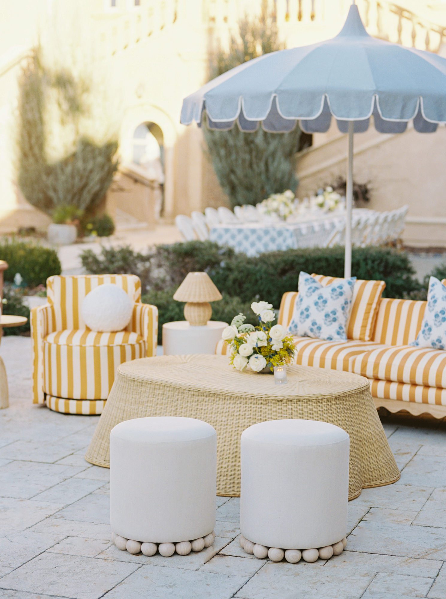 Outdoor lounge vignette with striped seating, woven textures, and coastal-inspired color palette.