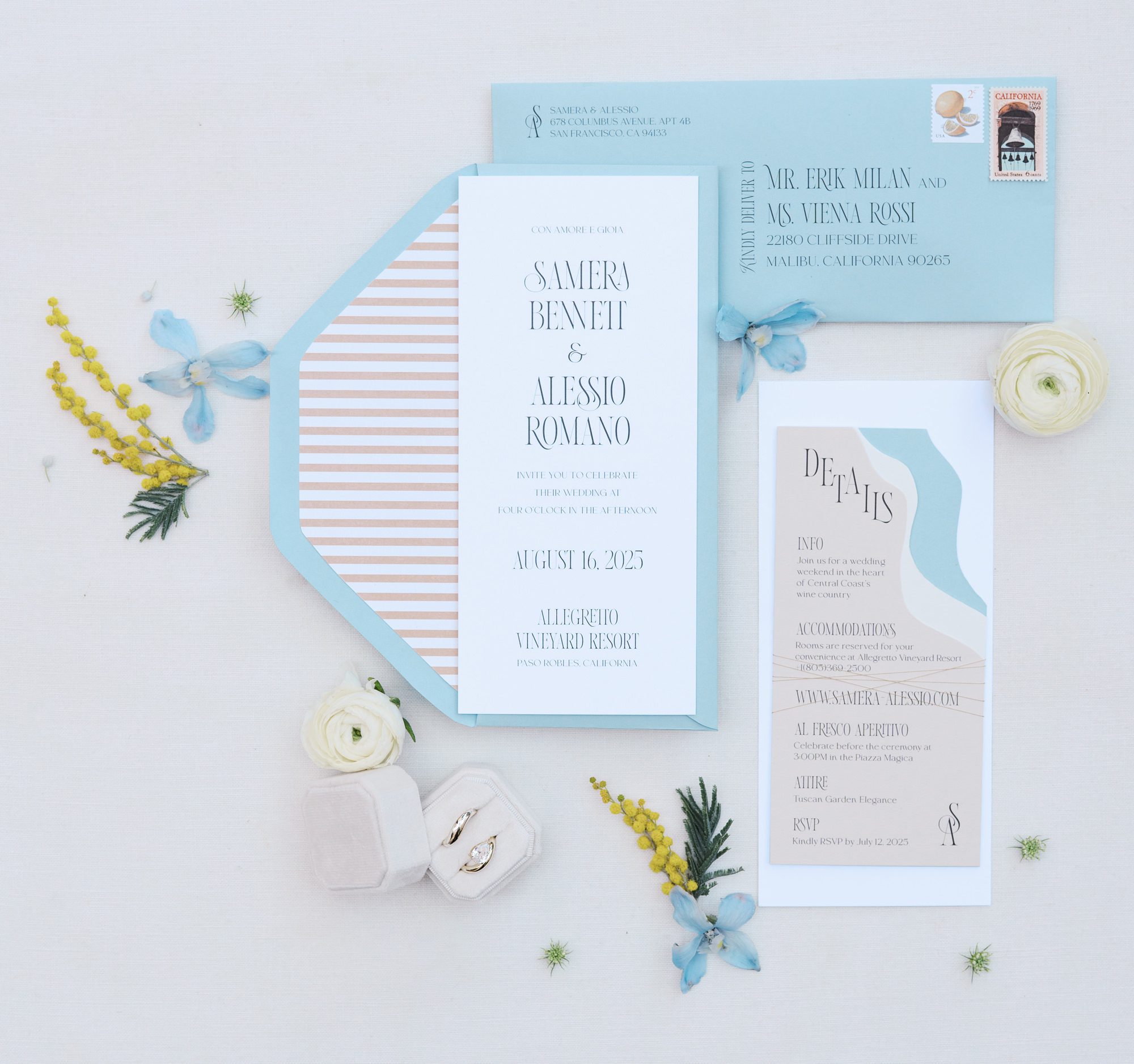 Amalfi Coast–inspired wedding invitation suite with shoreline die cut, blue envelopes, striped liner, and editorial typography.