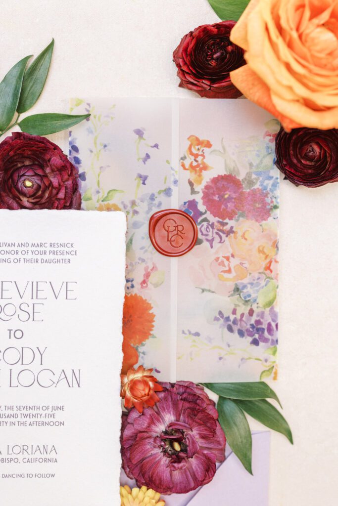 Wedding invitation with vellum wrap and deep red wax seal monogram
