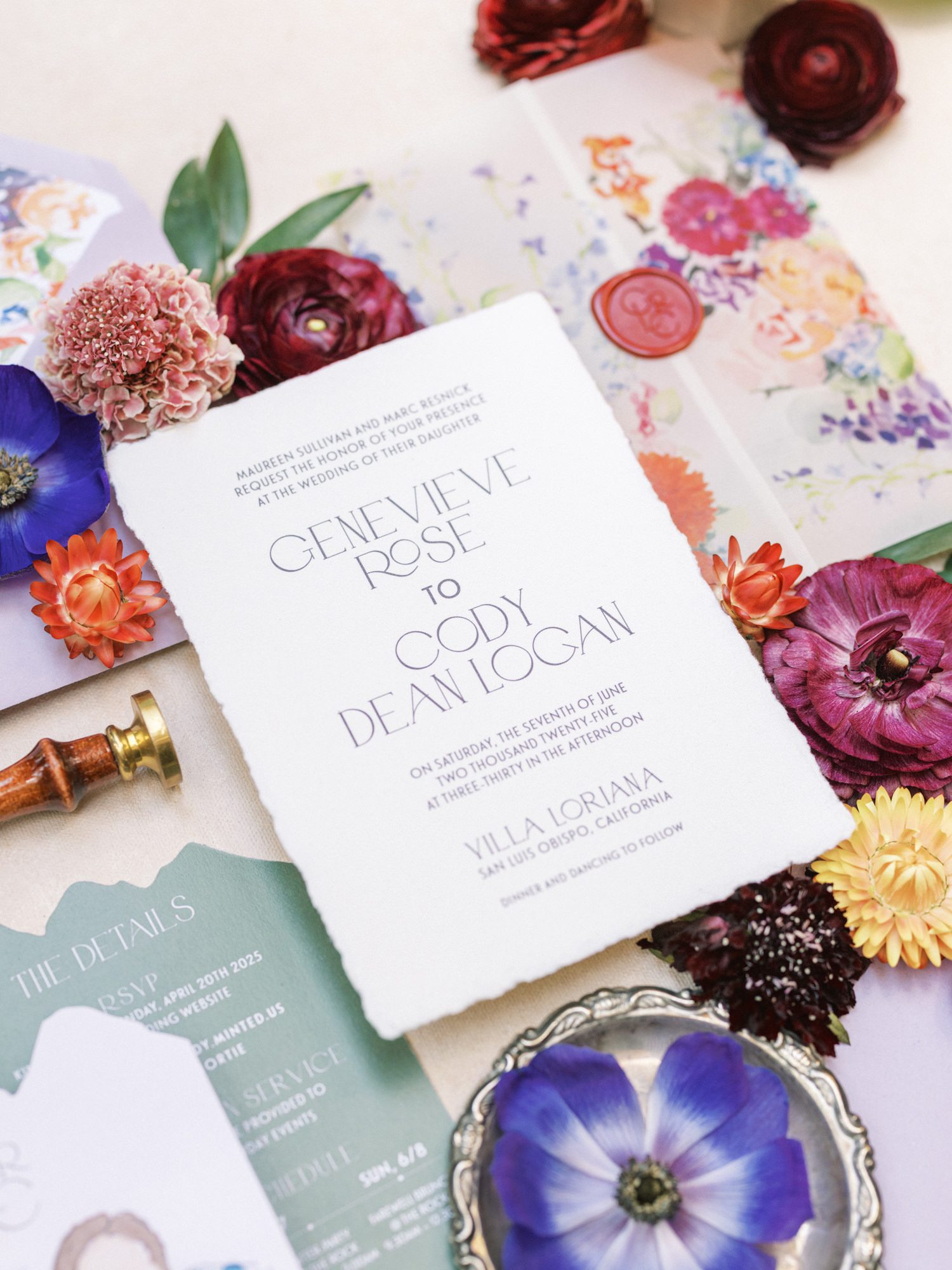 Wedding invitation with deckled edges surrounded by colorful florals and watercolor envelope liner
