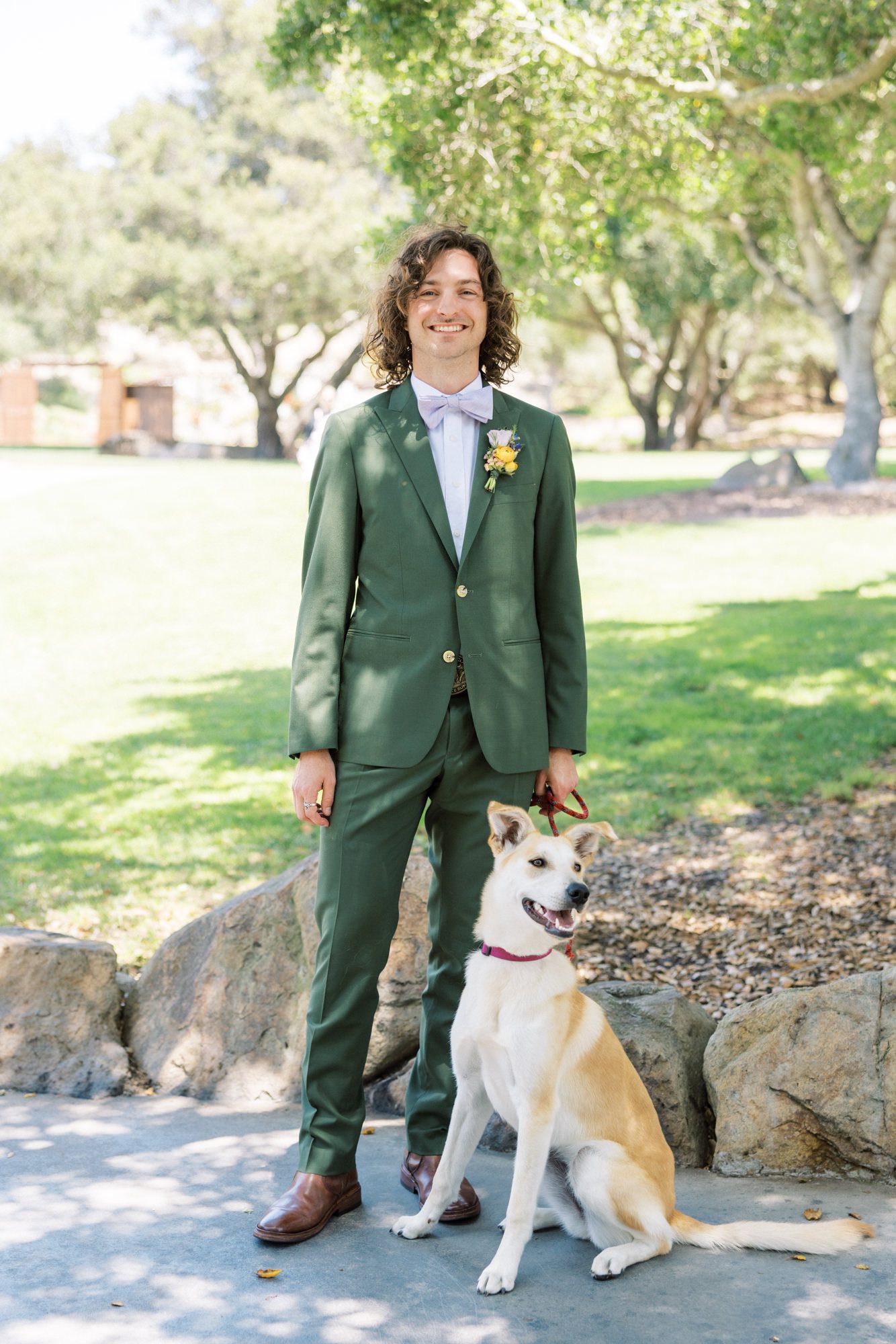 Bride and groom with dog at outdoor wedding venue in garden setting
