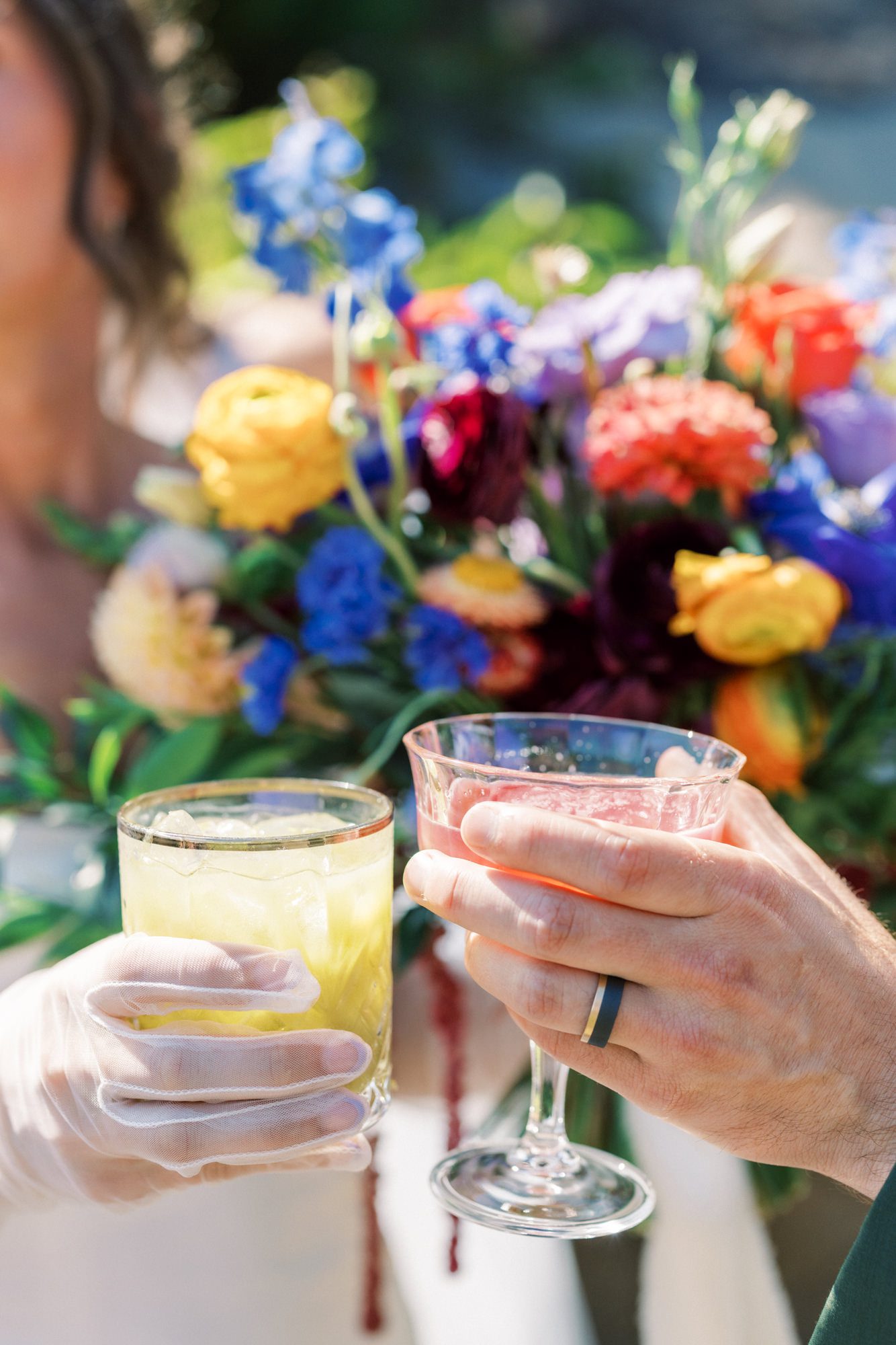 Colorful wedding florals next to cocktail glass with vibrant garden palette