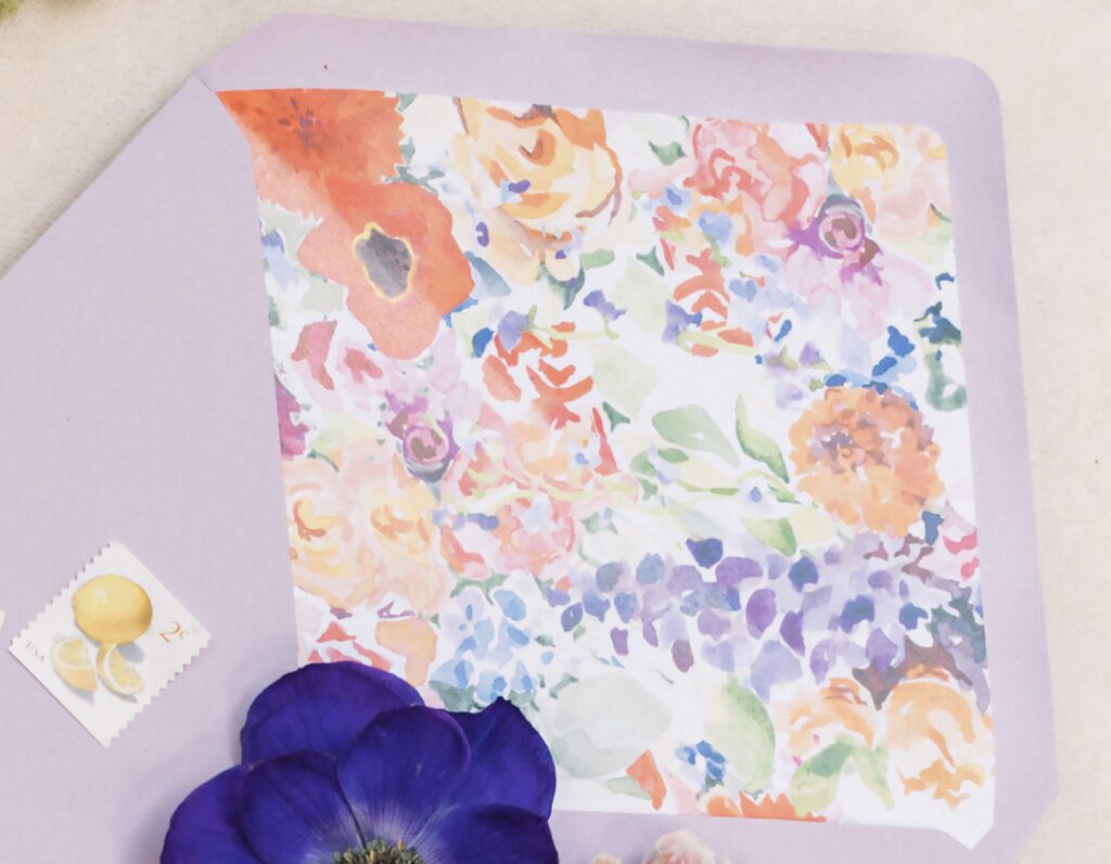 Watercolor floral envelope liner in lavender, coral, and deep blue tones