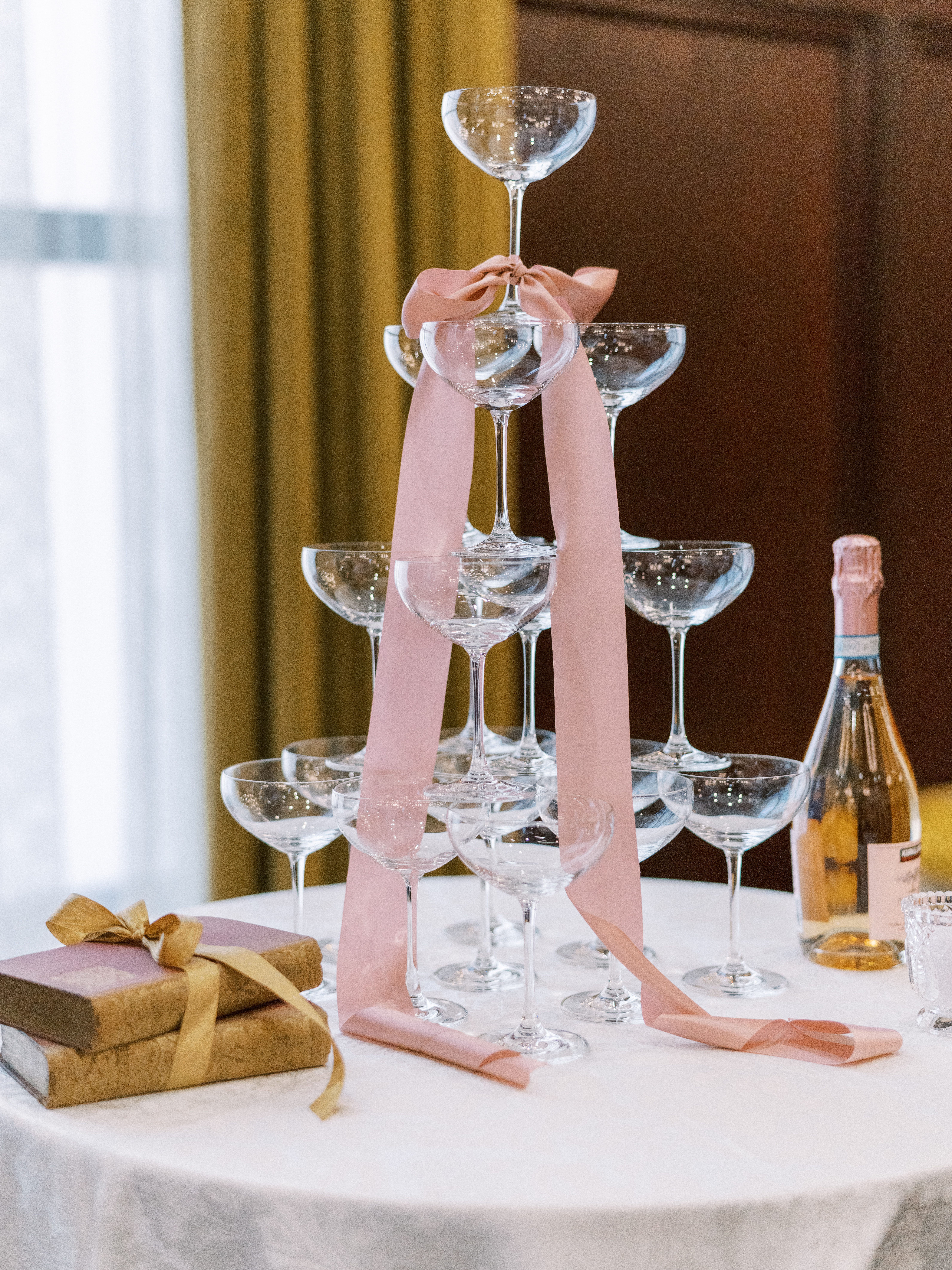 Champagne tower styled with blush ribbon for wedding reception