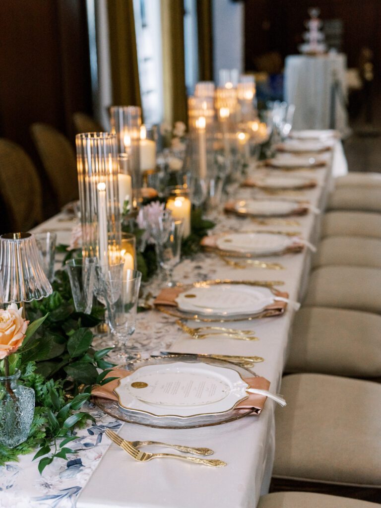 Long wedding reception table with candlelight, florals, and hand-torn paper menus
