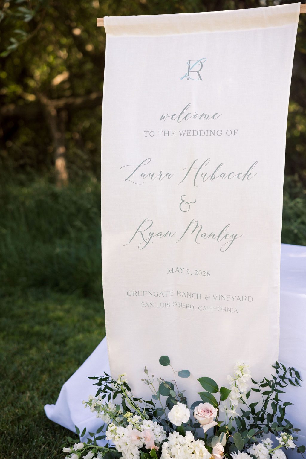 Custom linen wedding welcome sign with Laura and Ryan's LR monogram